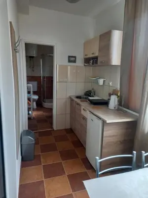 a kitchen with wooden cabinets and a tiled floor at Studio Dina in Becici