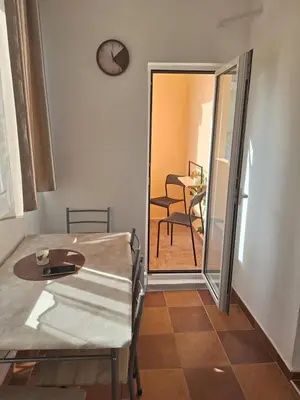 a dining room with a table and a clock on the wall at Studio Dina in Becici