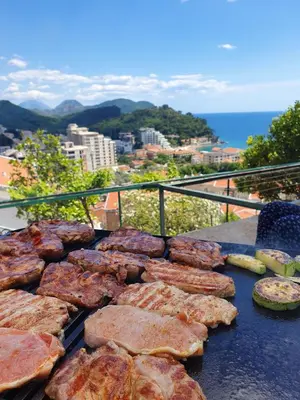 a grill with meat and vegetables on top of a balcony at Apartman Lana in Petrovac na Moru