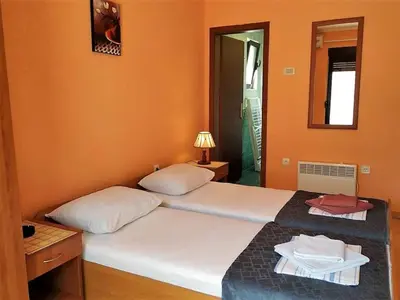 a bedroom with two beds and a mirror at Villa Budvanka Guesthouse in Budva
