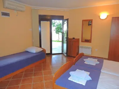 a bedroom with a bed and a table and a mirror at Villa Budvanka Guesthouse in Budva
