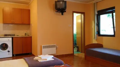 a small room with a bed and a washing machine at Villa Budvanka Guesthouse in Budva