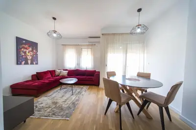 a living room with a red couch and a table at SUN apartment in Podgorica