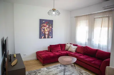 a living room with a red couch and a table at SUN apartment in Podgorica