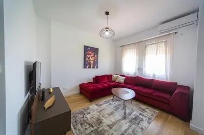 a living room with a red couch and a tv at SUN apartment in Podgorica