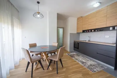 a dining room with a table and chairs in a kitchen at SUN apartment in Podgorica