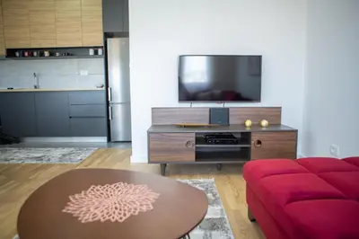 a living room with a red couch and a table at SUN apartment in Podgorica