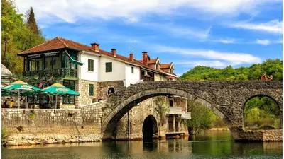 a building on top of a bridge over a river at Holiday home in Rijeka Crnojevića