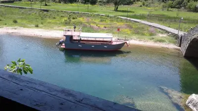 a boat in the water under a bridge at Holiday home in Rijeka Crnojevića