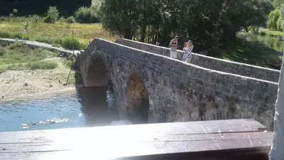 two people standing on a bridge over a river at Holiday home in Rijeka Crnojevića