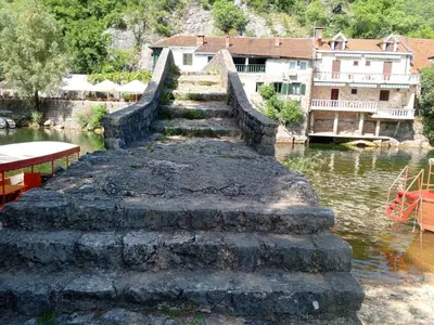 a stone bridge over a river with buildings in the background at Holiday home in Rijeka Crnojevića