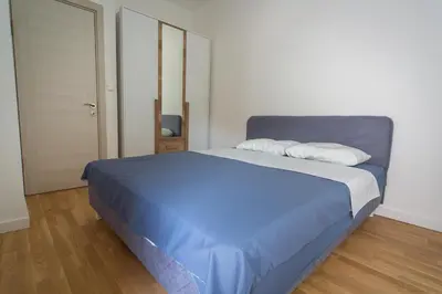 a bedroom with a bed with blue sheets and a door at Blue moon apartment in Podgorica