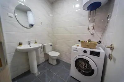 a bathroom with a washing machine and a sink at Blue moon apartment in Podgorica