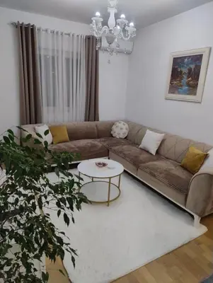 a living room with a couch and a table at Lovely apartment - Ljupki stan in Podgorica