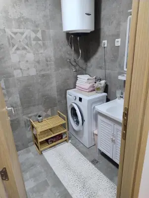a bathroom with a washing machine and a sink at Lovely apartment - Ljupki stan in Podgorica