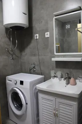 a bathroom with a washing machine and a sink at Lovely apartment - Ljupki stan in Podgorica