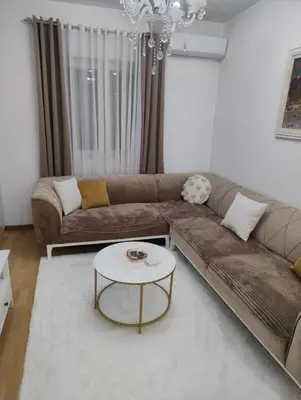 a living room with a couch and a table at Lovely apartment - Ljupki stan in Podgorica