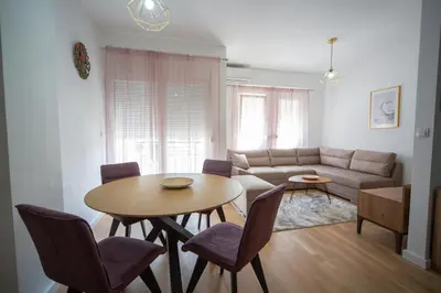 a living room with a table and a couch at East Side Apartment in Podgorica