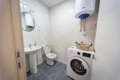 a bathroom with a washing machine and a sink at East Side Apartment in Podgorica