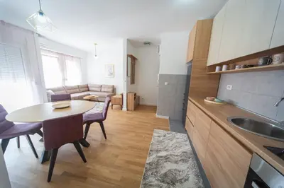 a kitchen and living room with a table and a sink at East Side Apartment in Podgorica