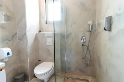 a bathroom with a toilet and a shower at Lux Hotel M in Dobra Voda