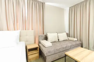 a small living room with a couch and a bed at Lux Hotel M in Dobra Voda