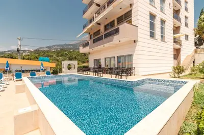 a swimming pool in front of a building at Lux Hotel M in Dobra Voda