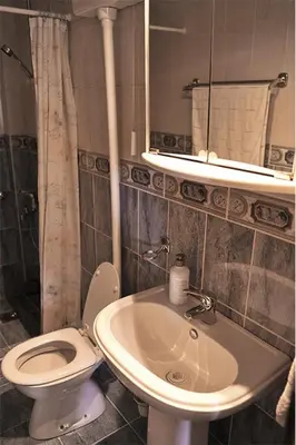 a bathroom with a sink and a toilet and a mirror at Vila Mila in Petrovac na Moru