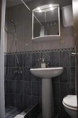 a bathroom with a sink and a toilet and a mirror at Vila Mila in Petrovac na Moru
