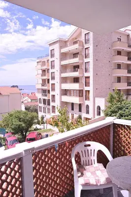 a balcony with two chairs and a table and a building at Vila Mila in Petrovac na Moru