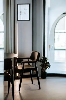 a chair and a table in a room with a window at Hotel Septembar in Podgorica