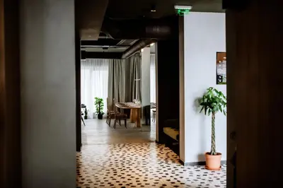 a hallway with a room with a table and a plant at Hotel Septembar in Podgorica