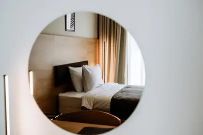 a hotel room with a bed and a mirror at Hotel Septembar in Podgorica
