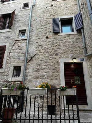 a building with two balconies and flowers on a fence at Puerta Apartments in Kotor