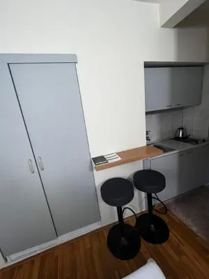 a small kitchen with two stools and a counter at Puerta Apartments in Kotor