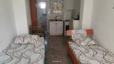 two beds in a small room with a kitchen at Apartment Panorama in Bar