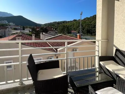 a balcony with chairs and a view of a building at Lana apartment Petrovac in Petrovac na Moru