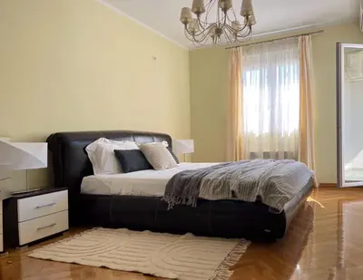 a bedroom with a large bed and a chandelier at Lana apartment Petrovac in Petrovac na Moru