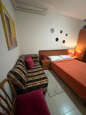 a bedroom with two beds and a couch at Apartment Plazza Rafailovici in Rafailovici