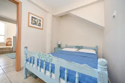 a bedroom with a blue bed in a room at Apartment Plazza Rafailovici in Rafailovici