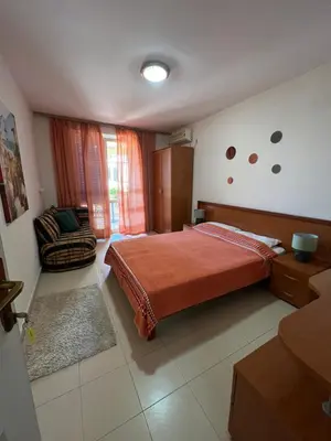 a bedroom with a bed and a chair in it at Apartment Plazza Rafailovici in Rafailovici