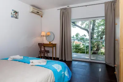 a bedroom with a bed and a large window at Vila Hrastovi in Sutomore