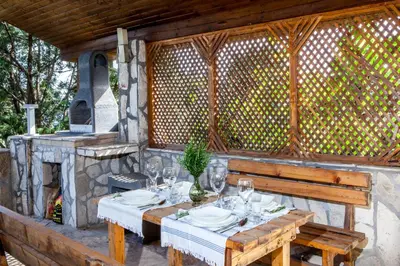 a wooden table with wine glasses and a fireplace at Vila Hrastovi in Sutomore