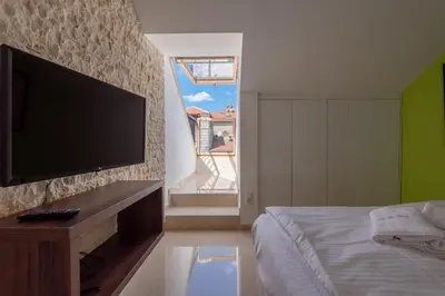 a bedroom with a bed and a flat screen tv at apartman365kotor in Kotor