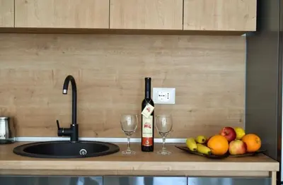 a kitchen counter with a sink and two glasses of wine at Sofija in Ulcinj