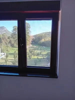 a window in a room with a view of a field at Lucha apartman in Rijeka Crnojevića