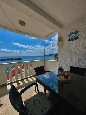 a dining room with a table and a view of the ocean at Pine&Sea Beach Retreat in Sveti Stefan