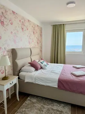 a bedroom with a bed and a window with the ocean at Pine&Sea Beach Retreat in Sveti Stefan
