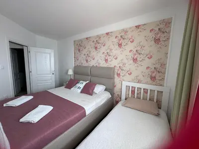 two beds in a bedroom with pink floral wallpaper at Pine&Sea Beach Retreat in Sveti Stefan
