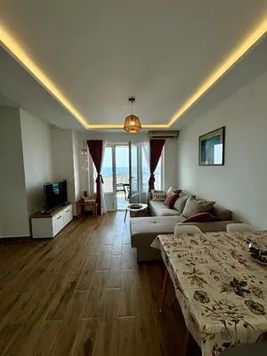 a living room with a couch and a table and a television at Pine&Sea Beach Retreat in Sveti Stefan
